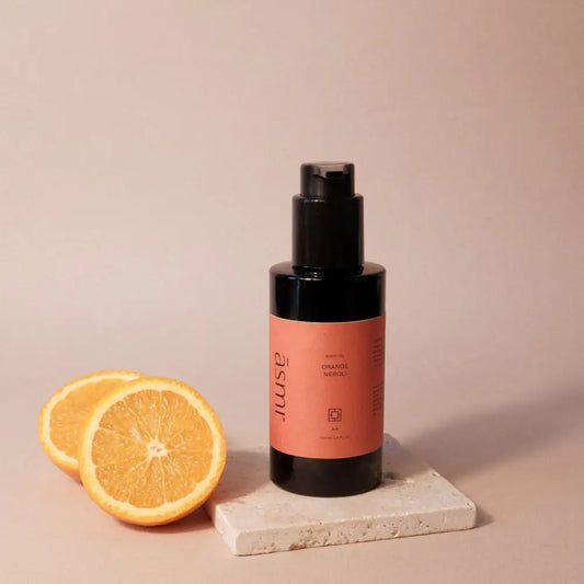 ASMI AYURVEDA BODY OIL ORANGE & NEROLI 100ml - Spender neben Orangenhälften