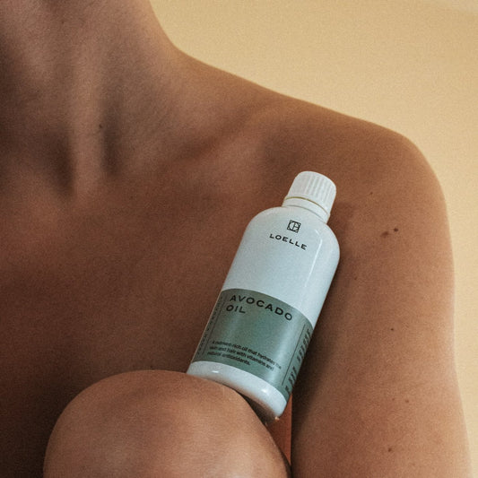 LOELLE ORGANICS Avocado Öl 100ml - Person zeigt Flasche