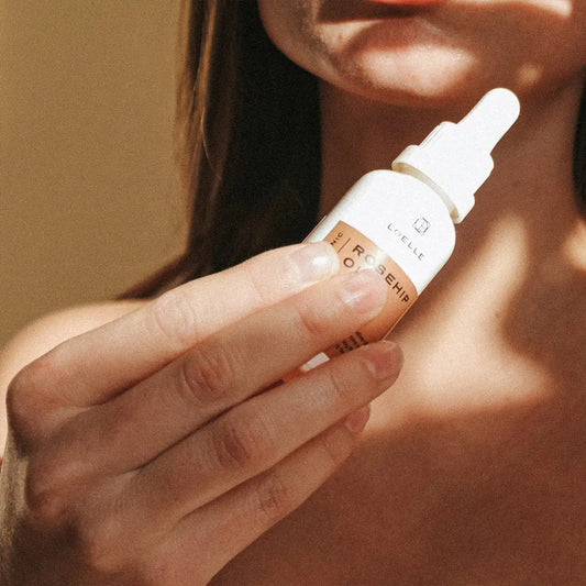 LOELLE ORGANICS Frau mit Hagebuttenöl in Hand 